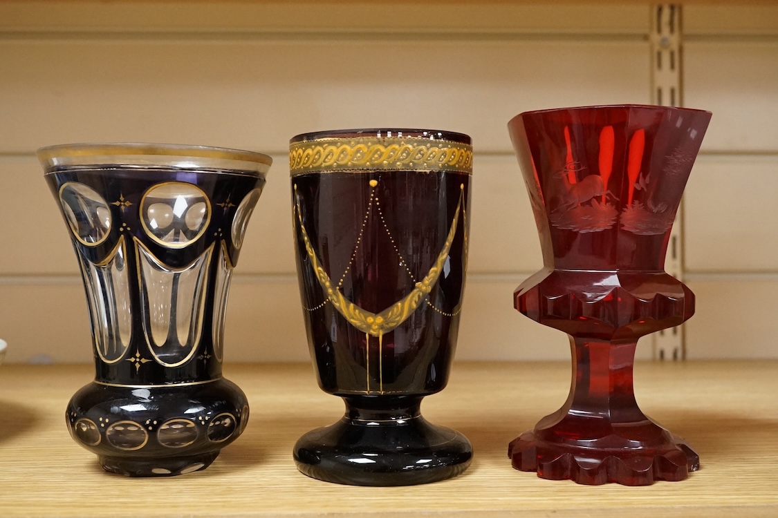 A 19th century Bohemian engraved ruby glass goblet, a similar amethyst and clear overlaid glass vase and an enamelled amethyst glass goblet, largest 15cm high